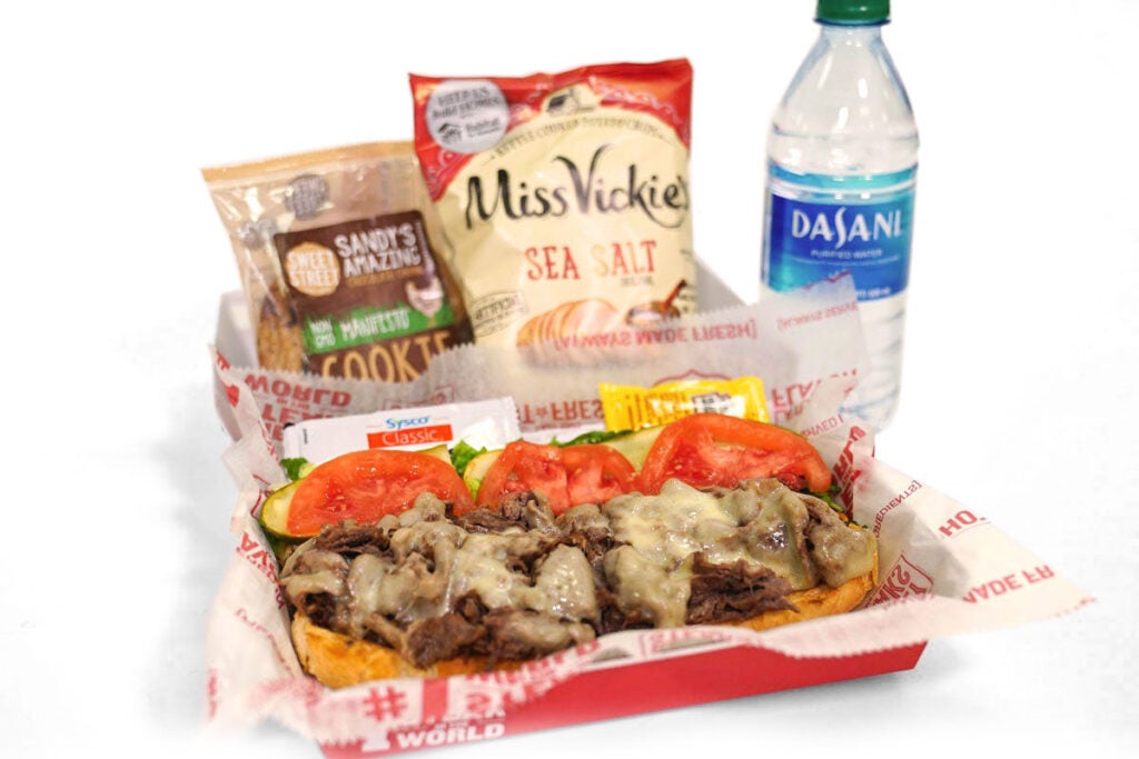 A catering boxed meal from Charleys Cheesesteaks. Charleys lunch boxes include your choice of steak, chicken, or veggie cheesesteak, chips, a cookie, and a bottled water. Catered lunch near me. Boxed lunches catering.