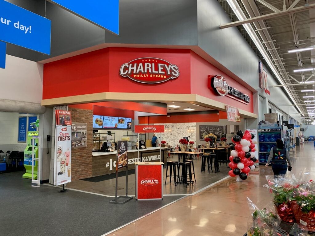 The front entrance of Charleys Cheesesteaks and Wings during grand opening at Juliet Blvd. Walmart in Naples, FL. This features the front entrance of the store with signs and balloons to celebrate the grand opening.